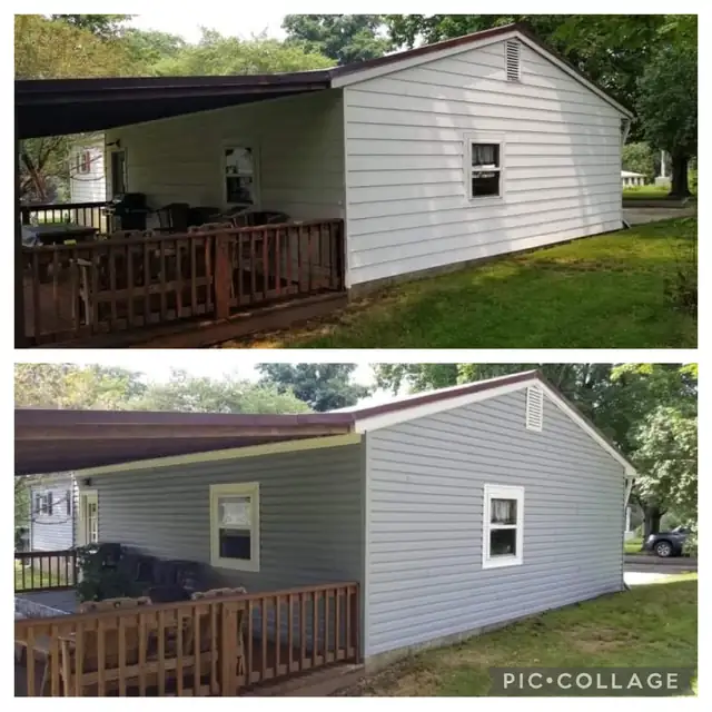 Single-story house with gray vinyl siding, white window trim and a wood deck railing